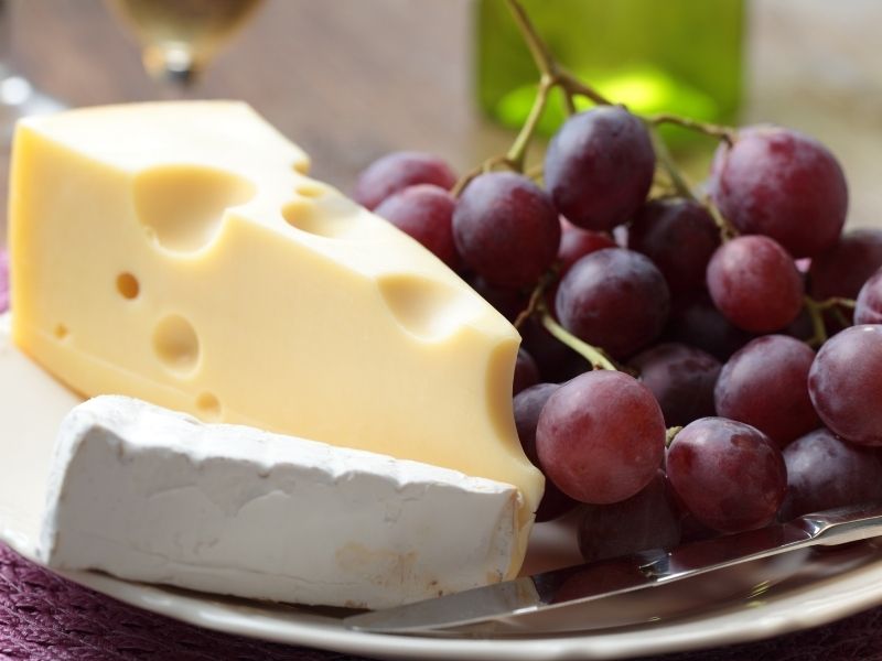 A plate with grapes and cheese