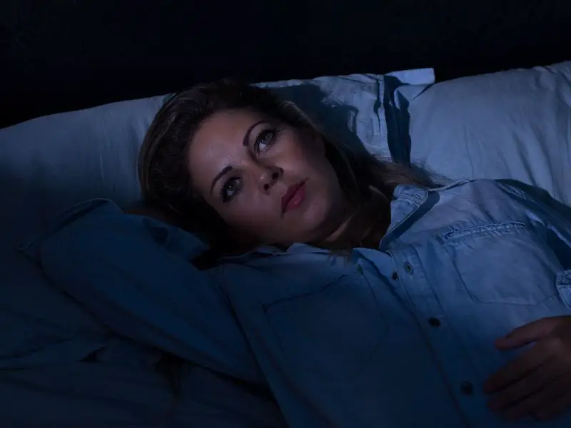 Girl laying in bed with insomnia