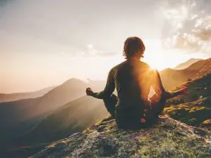 Man meditating on a mountain top