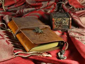 A grief journal and memory box sitting on a red shawl